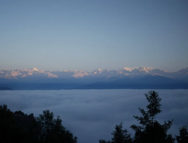 Sunrise in the Himalayas seen from the farm. The valley below is covered in fog early morning.
